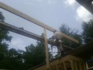 Carpenter setting a ridge beam over a new addition frame — Ice Dam Removal by Roofing Brothers in Havana