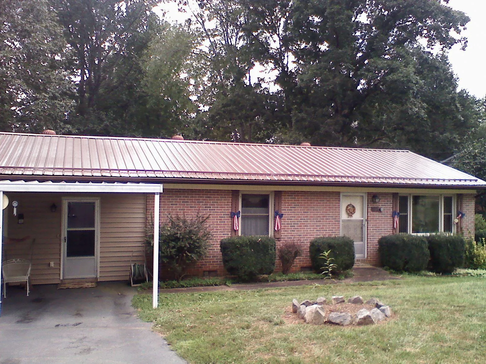 Bronze metal roof and carport on a brick ranch home — Roof Repair work by our crew in Havana
